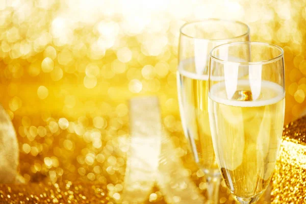 香槟金色背景与闪烁灯上的眼镜及礼品盒 — 图库照片