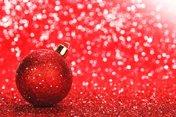 Κόκκινη Χριστουγεννιάτικη Μπάλα Πάνω Από Λαμπερό Φόντο Glitter — Φωτογραφία Αρχείου