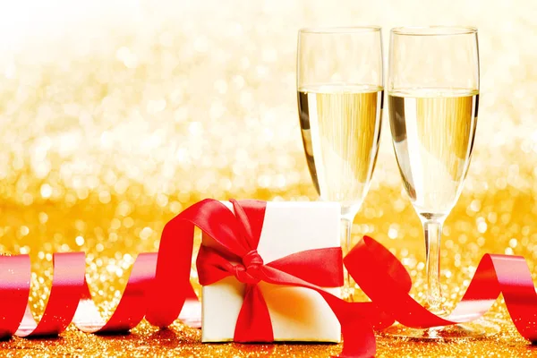 Champagne Glazen Aanwezig Witte Doos Met Rood Lint Gouden Achtergrond — Stockfoto