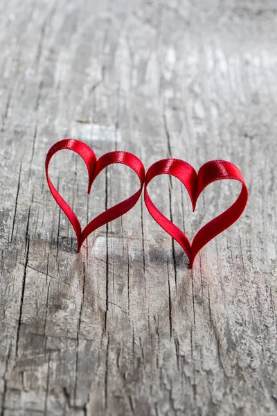 木製の背景に2つの赤いリボンの心 バレンタインデーのコンセプト — ストック写真