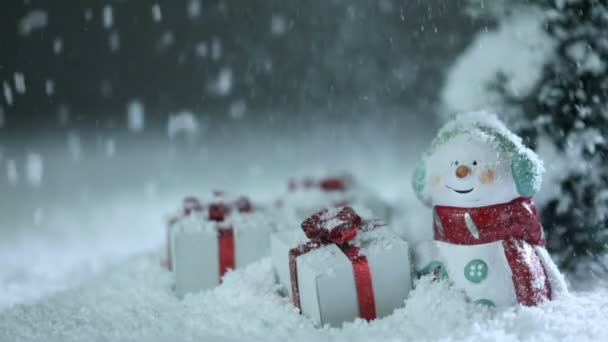 Schneemann Tanne Und Weihnachtsgeschenke Auf Schneewehen Unter Fallendem Schnee — Stockvideo