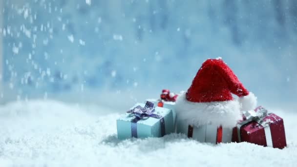 Sombrero Santa Cajas Regalos Decorados Deriva Nieve Sobre Fondo Azul — Vídeo de stock