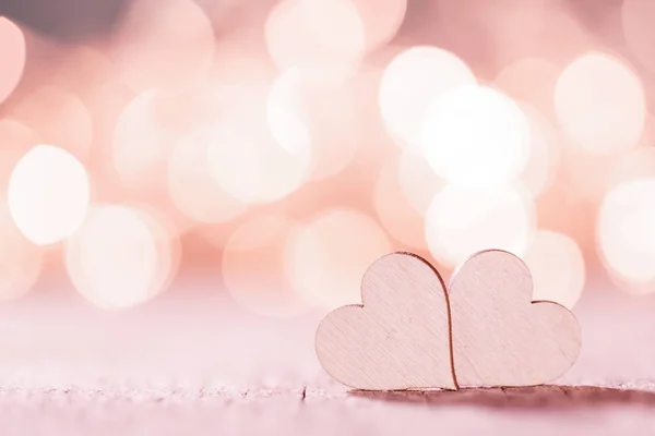 明るいライトの上の2つの小さな手作りピンクの木製の心 Bokeh Background — ストック写真