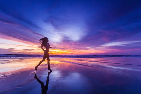 Menina correr na praia ao pôr do sol — Fotografia de Stock