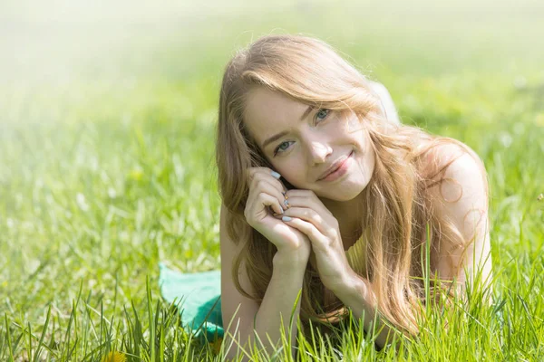 Meisje op het gras te leggen — Stockfoto