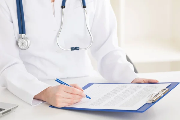 Médico femenino llenando historia del paciente —  Fotos de Stock