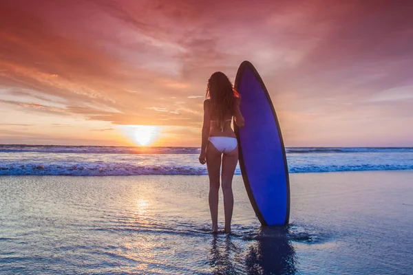 Surfař žena na pláži při západu slunce — Stock fotografie