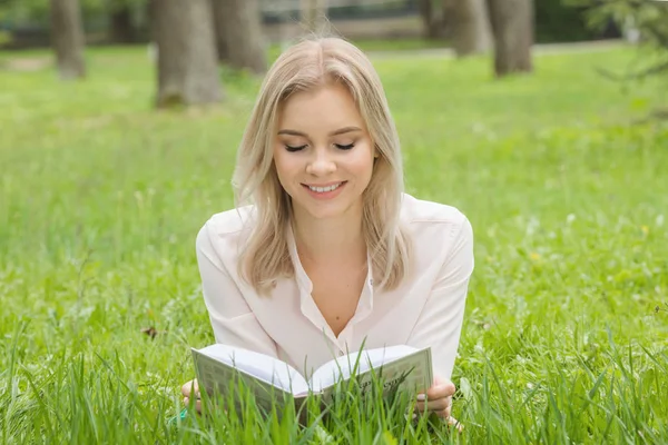 Kız okuma kitabı çimenlerin üzerinde — Stok fotoğraf