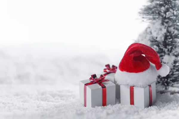 Pudełka na prezenty w śniegu pod drzewem — Zdjęcie stockowe