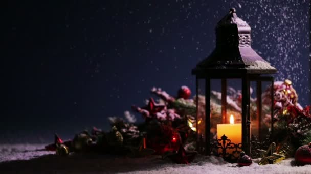 Ліхтар Свічкою Різдвяними Прикрасами Під Падаючим Снігом — стокове відео