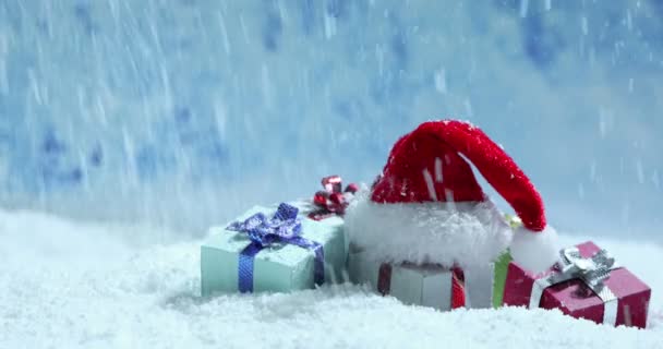 Chapéu Papai Noel Pequenos Presentes Decorativos Sob Queda Neve Fundo — Vídeo de Stock