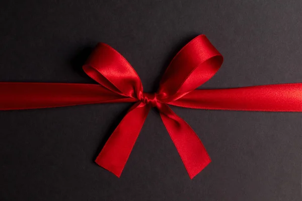 Red gift bow on black — Stock Photo, Image