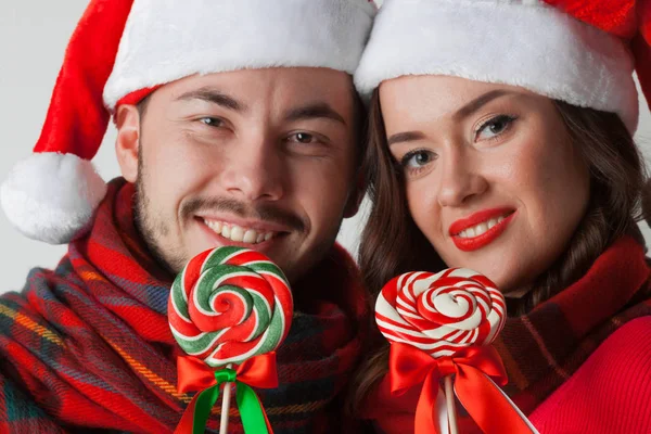 Para w świątecznych kapeluszach z lizakami — Zdjęcie stockowe