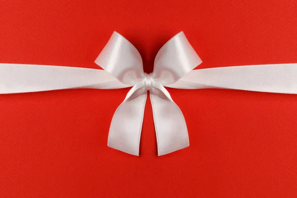 White gift bow on red — Stock Photo, Image