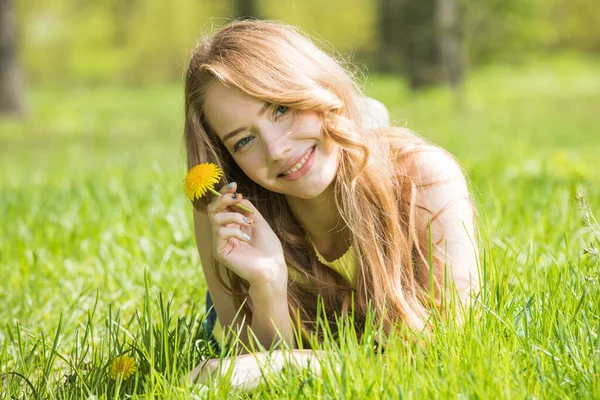 Χαρούμενη Χαμογελαστή Νεαρή Γυναίκα Ξαπλωμένη Στο Πράσινο Γρασίδι Κρατώντας Κίτρινο — Φωτογραφία Αρχείου