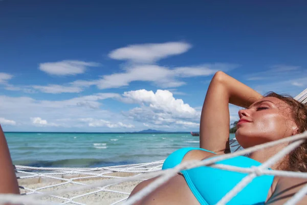 穿着比基尼的女孩在美丽的天堂海滩上的吊床上放松 — 图库照片