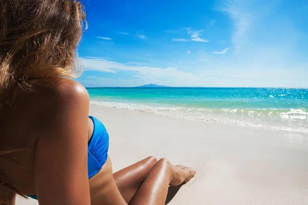 穿着比基尼的美丽的棕褐色女人躺在白色沙滩上眺望大海 — 图库照片