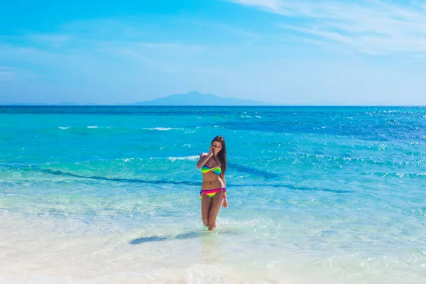 穿着比基尼的漂亮微笑的女孩站在透明的热带海水中 — 图库照片
