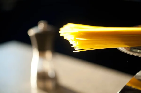 Espaguetis tipo pasta italiana en equilibrio con sal sobre fondo — Foto de Stock