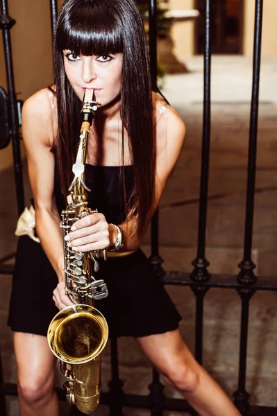 Joven morena jugando al saxo al aire libre — Foto de Stock