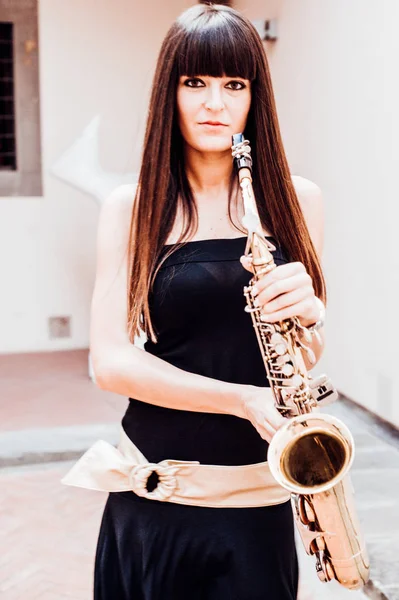 Joven morena jugando al saxo al aire libre —  Fotos de Stock