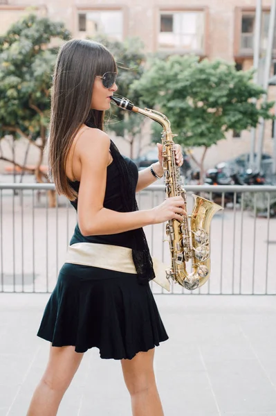 Joven morena jugando al saxo al aire libre —  Fotos de Stock