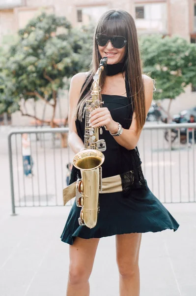 Joven morena jugando al saxo al aire libre —  Fotos de Stock