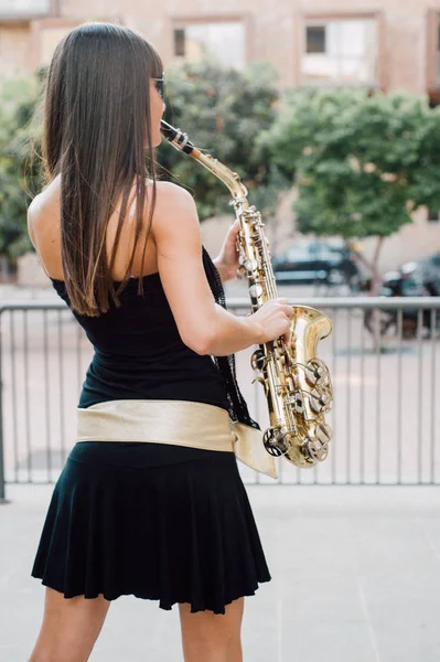 Joven morena jugando al saxo al aire libre —  Fotos de Stock