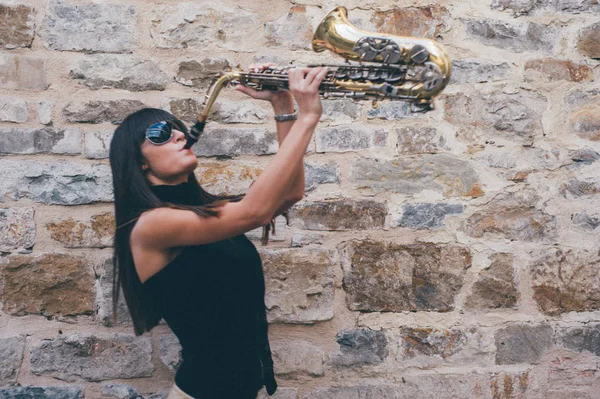 Joven morena jugando al saxo al aire libre —  Fotos de Stock