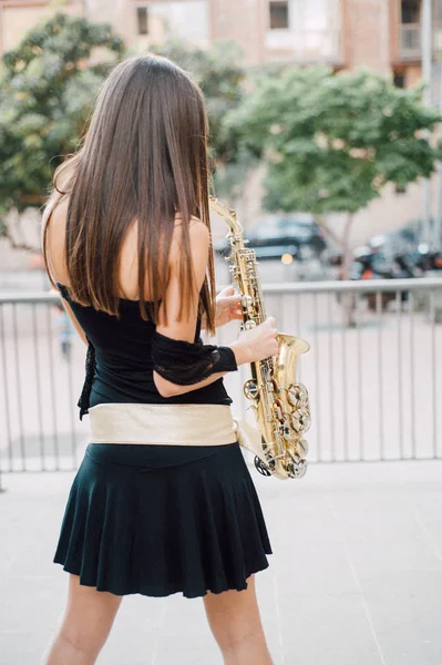 Joven morena jugando al saxo al aire libre —  Fotos de Stock