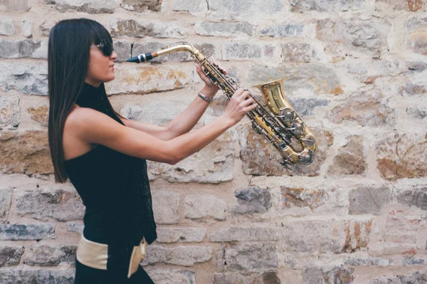 Joven morena jugando al saxo al aire libre — Foto de Stock