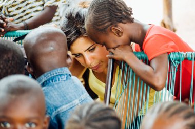 Beyaz beyaz genç kadın bir kırsal kasabada Afrikalı siyahlar ile çalış