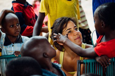 Beyaz beyaz genç kadın bir kırsal kasabada Afrikalı siyahlar ile çalış