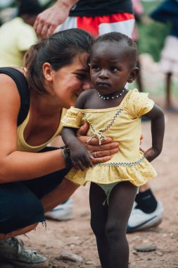 Mali, Afrika - Ağustos 2009 - yaklaşık beyaz beyaz genç kadın çalış Bamako yakınlarındaki kırsal bir kasabada siyah Afrika genç kızla