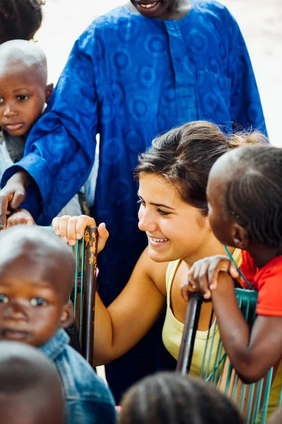 Kaukaski kobiece kobieta młody bawi się czarne african people w miasteczku — Zdjęcie stockowe