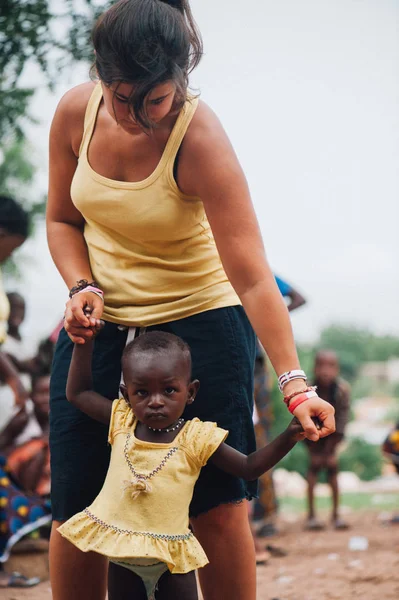 Kaukaski kobiece kobieta młody bawi się czarne african people w miasteczku — Zdjęcie stockowe