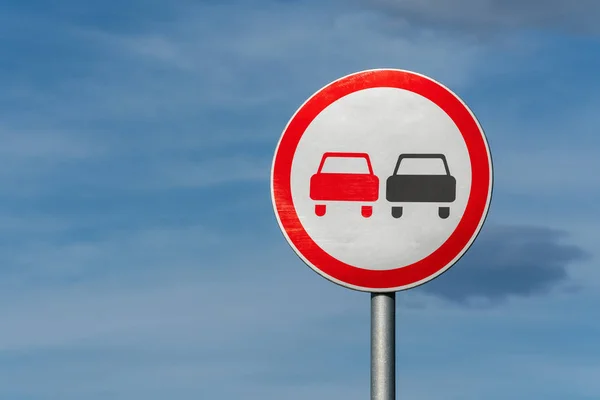 No overtaking road traffic sign with two cars. Information and warning road traffic street sign, compliance with rules. Copy space, background for education, learning and driving courses.