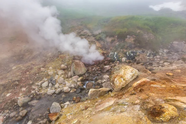 Breathtaking view of volcanic landscape, erupting fumarole, aggressive hot spring, gas-steam activity in crater of active volcano. Beautiful mountain landscape, travel destinations for active vacation