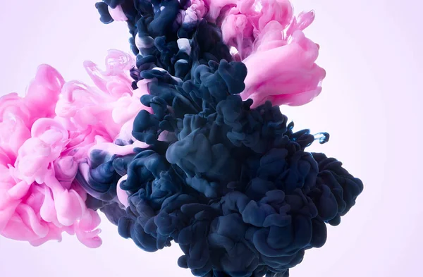 Color ink in water over pastel pink background