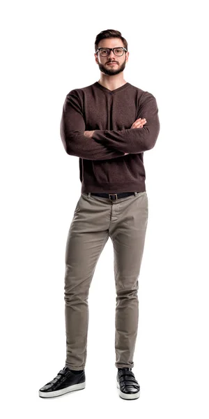 Een jonge man in casual kleding stands met handen gekruist aan de voorzijde uitzicht op een witte achtergrond. — Stockfoto