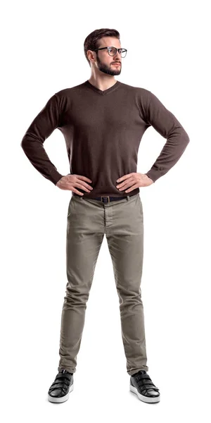 Un uomo barbuto in abiti casual sta con le mani sui fianchi isolato su uno sfondo bianco . — Foto Stock