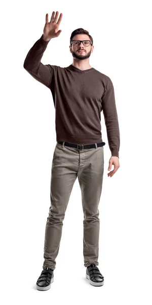 Un joven barbudo con pantalones de carga levanta la mano para tocar algo o saludar . —  Fotos de Stock
