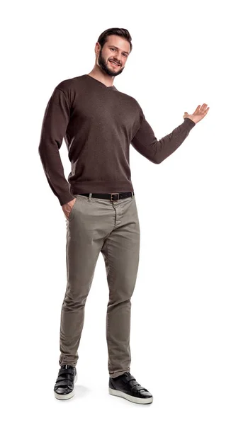 Ein Mann in Freizeitkleidung macht einen kurzen Schritt, lächelt und zeigt etwas mit einem Arm auf weißem Hintergrund. — Stockfoto