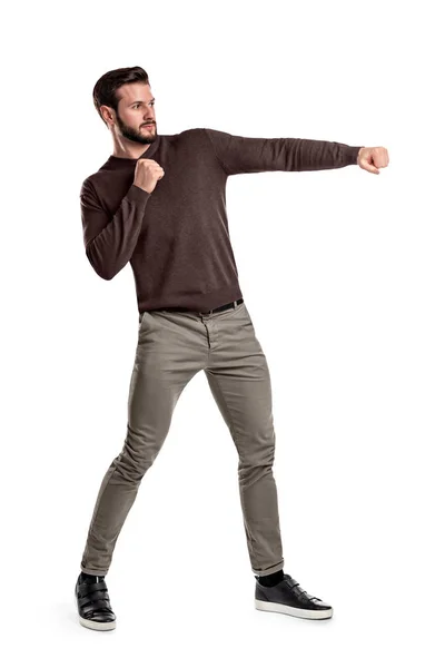 Een geïsoleerde bebaarde man in casual kleding stoten lege lucht op een witte achtergrond. — Stockfoto