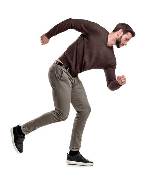 Μια τακτοποίηση γενειοφόρος άνδρας σε Βαμβακερό πουλόβερ στέκεται σε μια θέση μέσα τρέχοντας με χέρια ευρύ βοηθώντας να αποκτήσει ταχύτητα. — Φωτογραφία Αρχείου