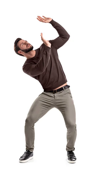 A bearded man in casual garb stands protecting himself with outstretched hands from something getting to him from above. — Stock Photo, Image