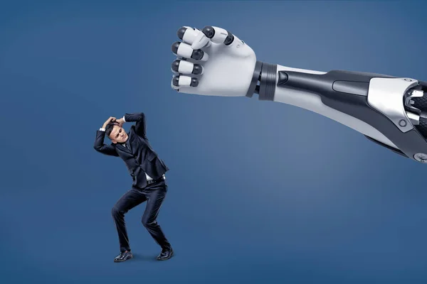 Una mano robotica gigante è pronta a colpire un piccolo uomo d'affari spaventato con un pugno . — Foto Stock