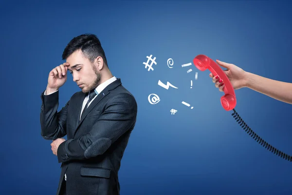 Ένας κουρασμένος επιχειρηματίας στέκεται γύρισε μακριά από ένα κόκκινο ρετρό τηλέφωνο σε ένα γυναικείο χέρι. — Φωτογραφία Αρχείου