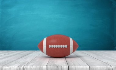 bir top Amerikan futbolu bir ahşap masa mavi bir arka plan üzerine yatan için 3D render.
