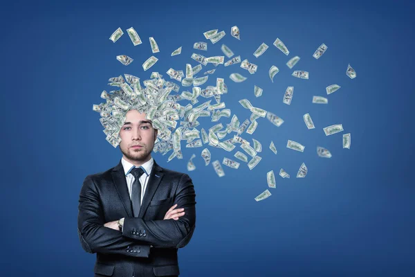 Zakenman met geld dollars vliegen uit zijn hoofd op blauwe achtergrond — Stockfoto